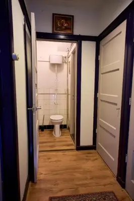 a bathroom with a toilet and a door leading to a room at Olympic's Little Palace in Amsterdam