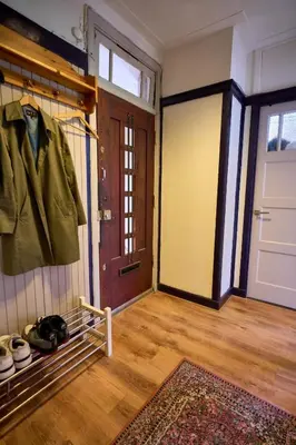a room with a door and a coat hanging on a rack at Olympic's Little Palace in Amsterdam
