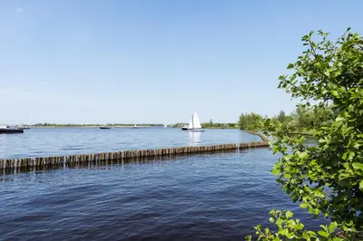 a sailboat in the middle of a river at Kaag Villas in Warmond