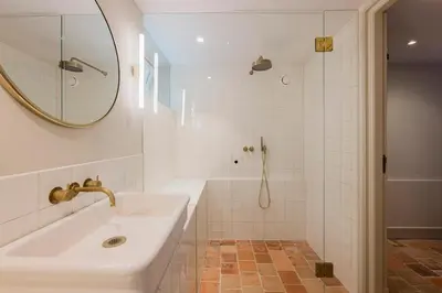 a white bathroom with a sink and a shower at Charming souterrain studio at Bloemgracht 30 in Amsterdam