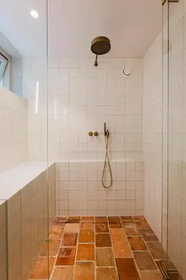 a bathroom with a shower with a glass door at Charming souterrain studio at Bloemgracht 30 in Amsterdam