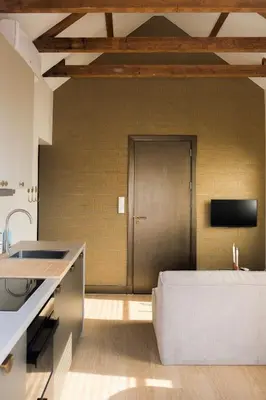 a kitchen with a couch in front of a door at Moyeni in Zandvoort