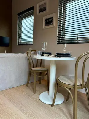 a table with two chairs and a table with wine glasses at Moyeni in Zandvoort
