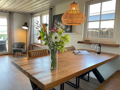 a vase of flowers sitting on a wooden table at De Tuinkamer in Egmond aan den Hoef