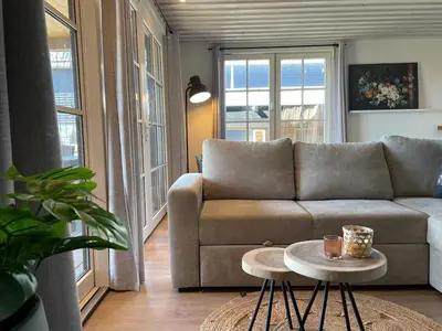 a living room with a couch and a table at De Tuinkamer in Egmond aan den Hoef