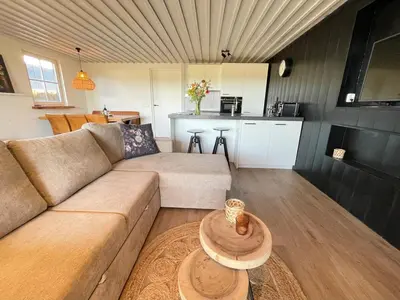a living room with a couch and a table at De Tuinkamer in Egmond aan den Hoef