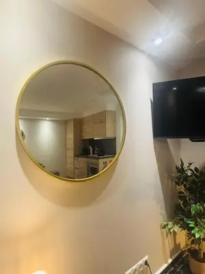 a round mirror on a wall with a kitchen at Duin 10 in Katwijk aan Zee