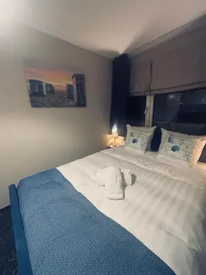 a bedroom with a large white bed with towels on it at Duin 10 in Katwijk aan Zee