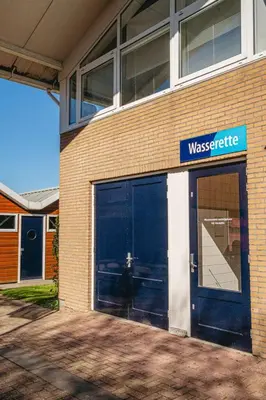 a building with two garage doors and a sign on it at Apartment Oostergeest 2 by Interhome in Uitgeest