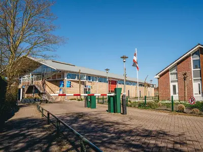 a school building with a fence in front of it at Apartment Oostergeest 2 by Interhome in Uitgeest