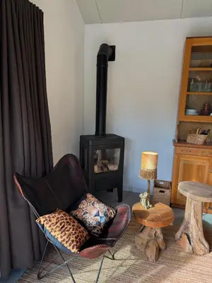 a living room with a chair and a wood stove at B&B Molenweg in Laren