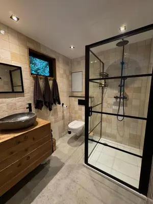 a bathroom with a glass shower and a toilet at B&B Molenweg in Laren