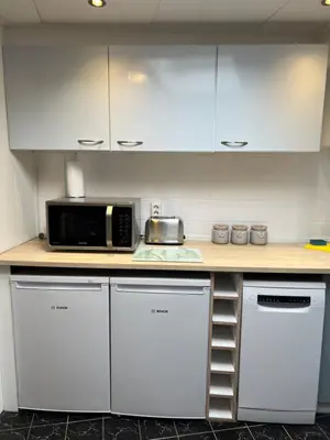 a kitchen with white cabinets and a microwave at Zeemeeuw aan Zee in Egmond aan Zee