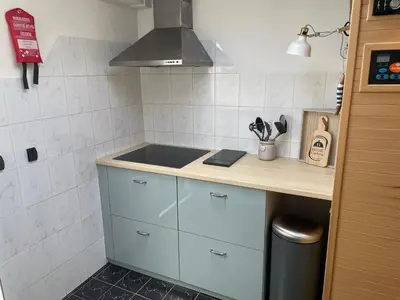 a small kitchen with a counter and a sink at Zeemeeuw aan Zee in Egmond aan Zee