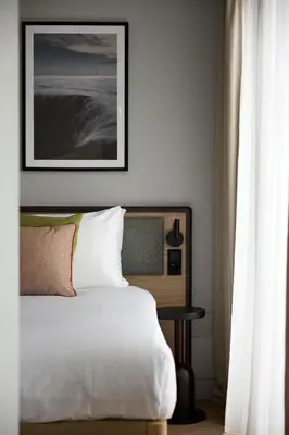 a bedroom with a white bed and a picture on the wall at Wilde Aparthotels Amsterdam Noord in Amsterdam