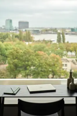 a table with a laptop on top of a window at Wilde Aparthotels Amsterdam Noord in Amsterdam