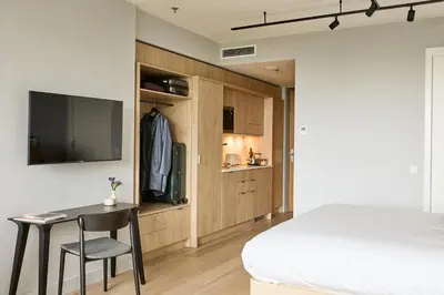 a bedroom with a bed and a table and a tv at Wilde Aparthotels Amsterdam Noord in Amsterdam