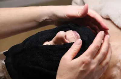 a person wrapping a black towel around a babies mouth at Weidezicht Soest, beauty & wellness en rust & natuur in Soest