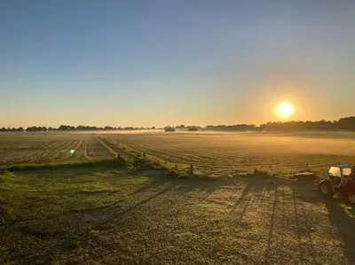 a tractor parked in a field at sunset at Weidezicht Soest, beauty & wellness en rust & natuur in Soest