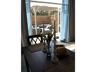 a wooden table with vases and flowers on it at One-bedroom apartment in Heemskerk