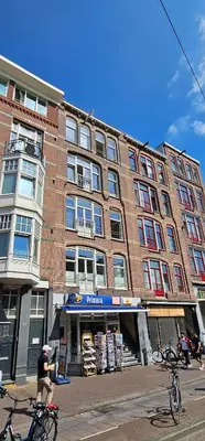 a man riding a bike in front of a building at Cozy Room in Oldwest with private bathroom in Amsterdam