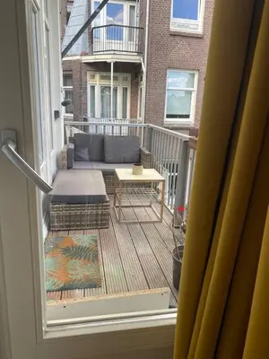 a balcony with a couch and a table on a porch at Cozy Room in Oldwest with private bathroom in Amsterdam