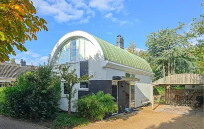 a white house with a green roof and a window at 2 Bedroom Beautiful Home In Noordwijkerhout in Noordwijkerhout