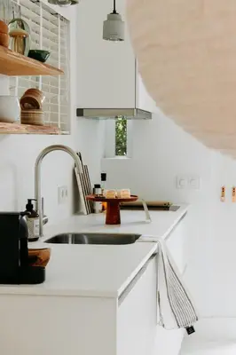 a kitchen with white cabinets and a sink at Sea and the City in Overveen