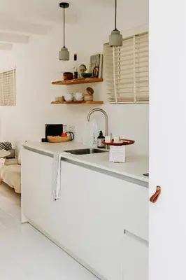 a kitchen with white countertops and a sink at Sea and the City in Overveen