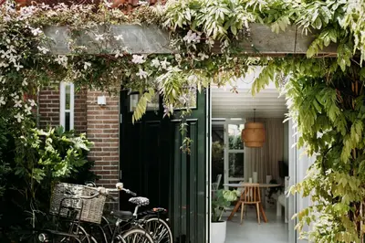 a bike parked in front of a house with a green door at Sea and the City in Overveen