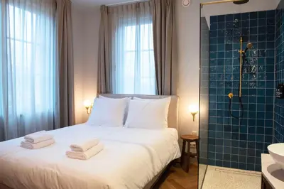 a bedroom with a bed and a shower with towels on it at Boetiekhotel Het Gezellenhuis in Ouderkerk aan de Amstel