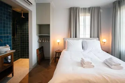a bedroom with a white bed with two towels on it at Boetiekhotel Het Gezellenhuis in Ouderkerk aan de Amstel
