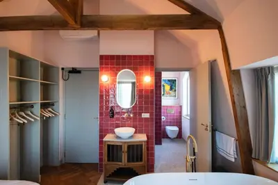a bathroom with a tub and a red tile wall at Boetiekhotel Het Gezellenhuis in Ouderkerk aan de Amstel