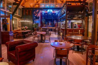 a restaurant with tables and chairs and a bar at Boetiekhotel Het Gezellenhuis in Ouderkerk aan de Amstel