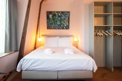 a bedroom with a bed with two towels on it at Boetiekhotel Het Gezellenhuis in Ouderkerk aan de Amstel