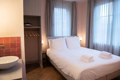 a bedroom with a bed with towels on it at Boetiekhotel Het Gezellenhuis in Ouderkerk aan de Amstel