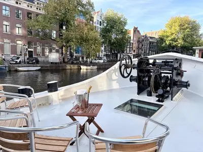 a camera on the back of a boat with chairs at Canal Suite on Houseboat in Amsterdam