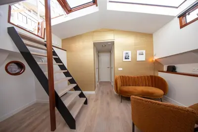 a living room with a staircase and a couch at Canal Suite on Houseboat in Amsterdam