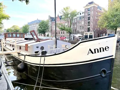a boat docked at a dock in the water at Canal Suite on Houseboat in Amsterdam