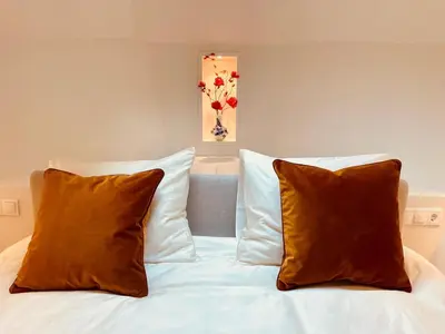 a bed with two pillows on top of it at Canal Suite on Houseboat in Amsterdam
