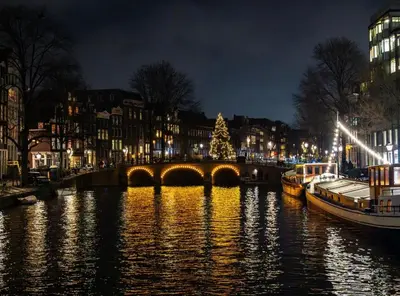a christmas tree on a bridge over a river at night at Canal Suite on Houseboat in Amsterdam
