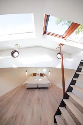 a bedroom with a bed in the middle of a room at Canal Suite on Houseboat in Amsterdam