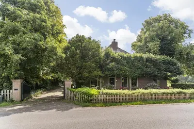 a brick house with a fence in front of it at Boerderijwoning 't Boetje in Heiloo