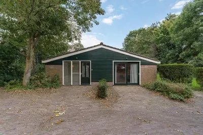 a green house with a driveway in front of it at Boerderijwoning 't Boetje in Heiloo