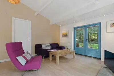 a living room with a purple couch and a table at Boerderijwoning 't Boetje in Heiloo