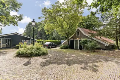a house with a car parked in front of a driveway at Boerderijwoning 't Boetje in Heiloo