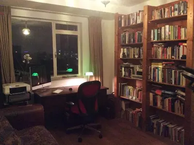 a room with a desk and book shelves filled with books at Welcoming Apartment with Character & Great Views in Amsterdam