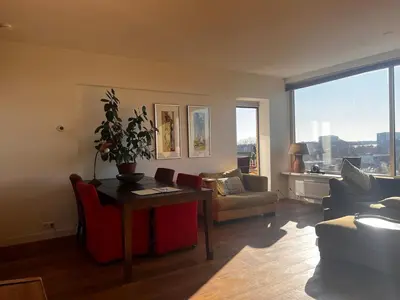a living room with a couch and a table with a plant at Welcoming Apartment with Character & Great Views in Amsterdam