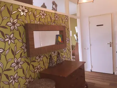 a mirror on a wall with a flowery wallpaper at Welcoming Apartment with Character & Great Views in Amsterdam
