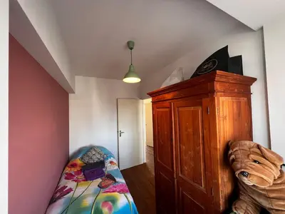 a bedroom with a bed and a wooden cabinet at Welcoming Apartment with Character & Great Views in Amsterdam
